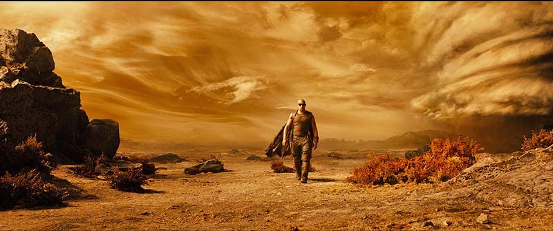 Vin Diesel as Riddick explores the desert planet on which he has been stranded.
