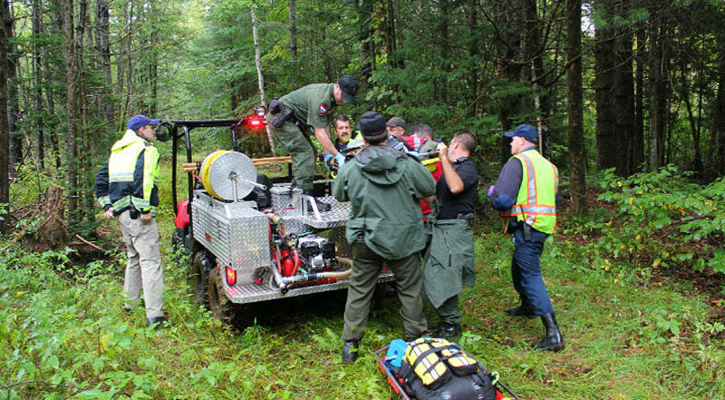 Rescuers takes Arthur Wakeman, 86, out of the woods near his Benton home on Friday.