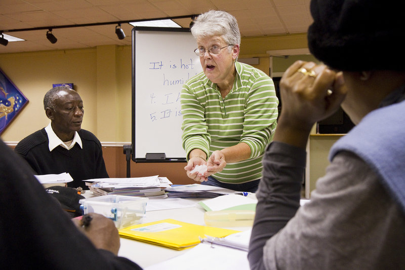 Betty Hartley, English conversation group instructor with Hope Acts in Portland, uses ice cubes to communicate the meaning of the word “ice” to students from the Democratic Republic of Congo and Burundi on Thursday.