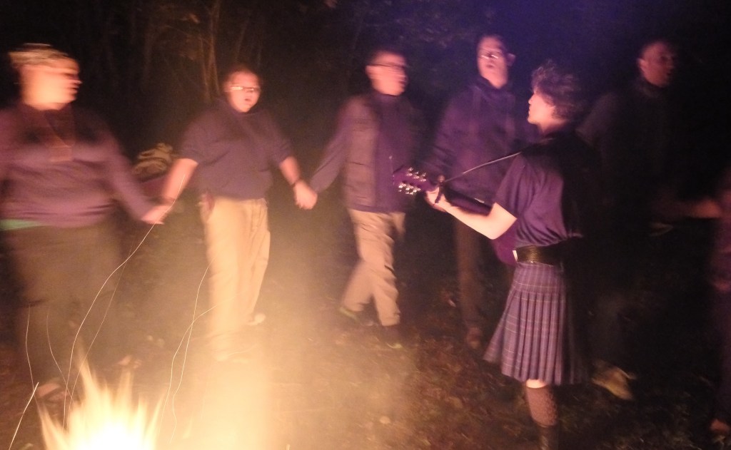 Kevin Emmons, right, of Hollis, plays the guitar as participants join hands and chant at the weaving in Casco.