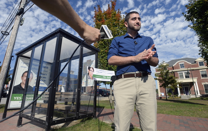 David Boyer of the Marijuana Policy Project speaks with the press near a bus shelter on Park Street in Portland that displays one of the ads in support of an initiative to remove penalties for marijuana possession.