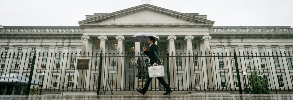 A pedestrian walks past the U.S. Treasury Building in Washington on Thursday, as the federal government shutdown continued.