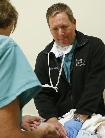 Dr. Keith Smith, right, of Surgery Center of Oklahoma, prepares a patient for surgery at the center in Oklahoma City on Oct. 10, 2013. Registered nurse Karen Barger is at left. Smith bids often on Medibid requests. He says his physician-owned center can offer better rates than some competitors because it doesnít charge a high facility fee like many hospitals do.