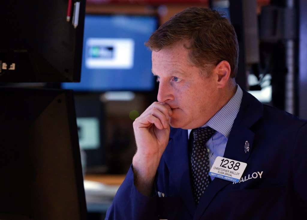 In this Wednesday, Oct. 2, 2013 file photo, Trader Christopher Malloy works on the floor of the New York Stock Exchange. Financial markets remained fixated Thursday on developments in Washington as the partial shutdown of the U.S. government entered its third day and showed few signs of being resolved soon.