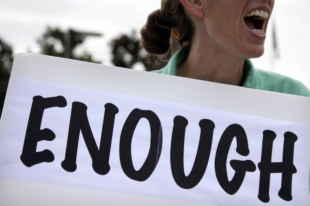 Vicki Maturo, of Culver City, Calif., protests against the government shutdown outside the federal building in Los Angeles on Wednesday, Oct. 2, 2013. President Barack Obama summoned congressional leaders to the White House on the second day of a partial government shutdown that has furloughed hundreds of thousands of workers and closed military cemeteries as far away as France.