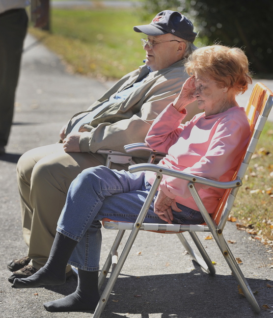Kathryn Crowley and her son Daniel Crowley watch from across the street Tuesday as firefighters put out a fire at their home.