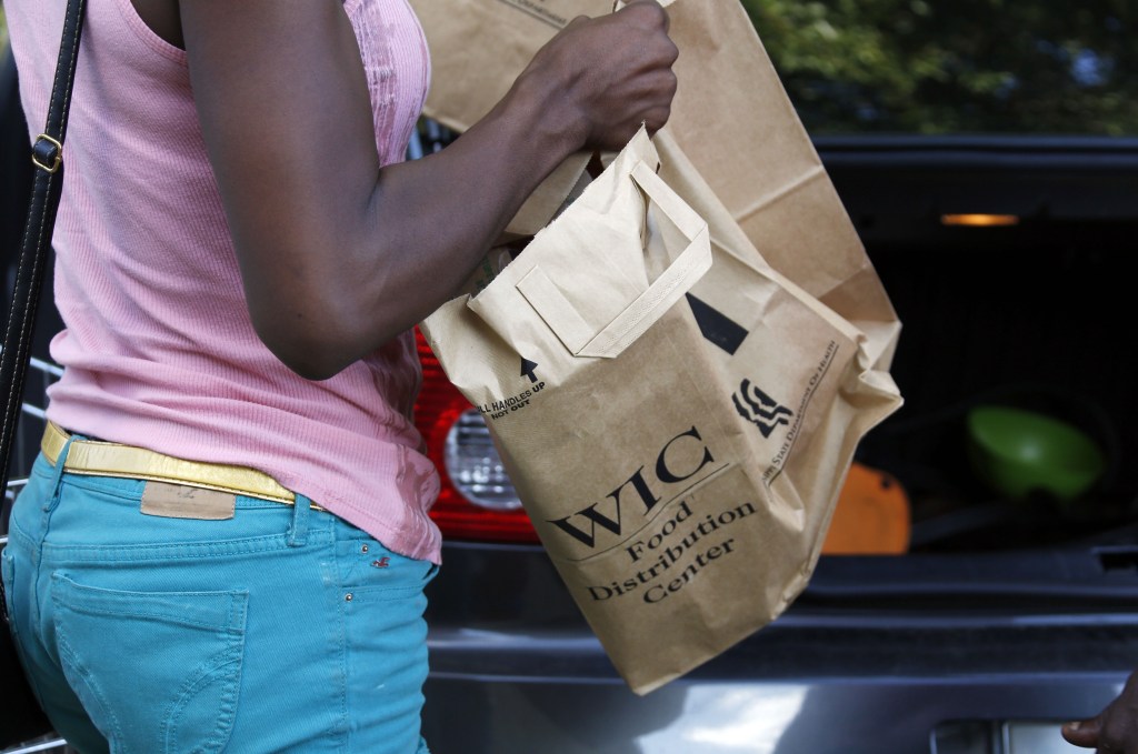 A recipient of the Special Supplemental Nutrition Program for Women, Infants and Children, better known as WIC, loads food into her car after leaving a center in Jackson, Miss., on Thursday. Despite a partial shutdown of the federal government, Mississippi has gotten permission to keep operating WIC through October. WIC helps pregnant, breastfeeding and post-partum women, plus infants and children younger than 5.