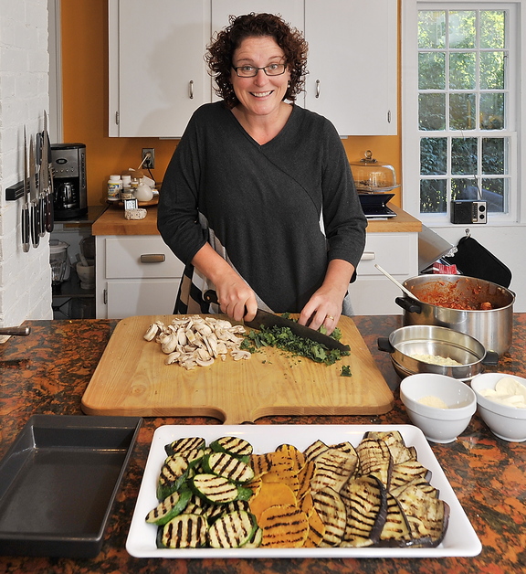 Cooking instructor Christine Burns Rudalevige chops kale and mushrooms in her Brunswick kitchen for her No-Noodle Vegetable and Turkey Lasagne. She created the recipe to use vegetables such as eggplant, zucchini or butternut squash that can be cut round and flat and grilled, in place of noodles, and added turkey and cheeses.