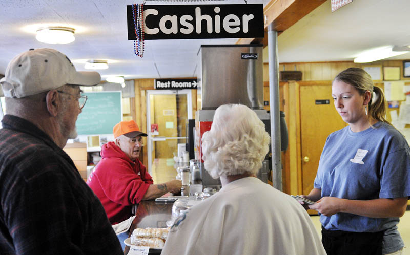 Hi-Hat waitress Caitlyn Laflin, right, gives customers change Monday on the eve of increases in meals, lodging and sales taxes in Maine. Meals and lodging taxes will increase from 7 percent to 8 percent and the sales tax will rise to 5.5 percent from 5 percent.