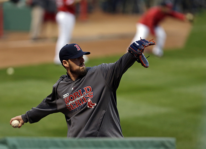 Boston Red Sox pitcher John Lackey throws during a baseball workout Tuesday, Oct. 22, 2013, in Boston. The Red Sox are scheduled to host the St. Louis Cardinals in Game 1 of baseball's World Series on Wednesday. MLB