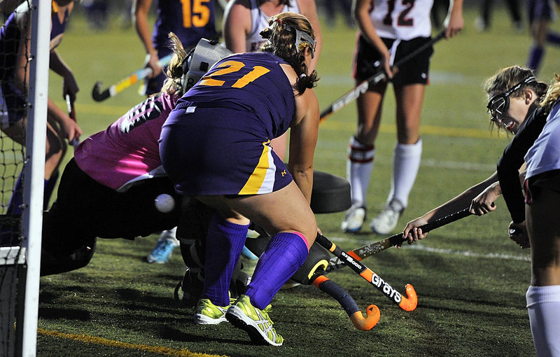 Anna Driscoll of Scarborough pops the ball through defense applied by Sarah Richter of Cheverus and goalie Libby DesRuisseaux to tie the game Thursday night