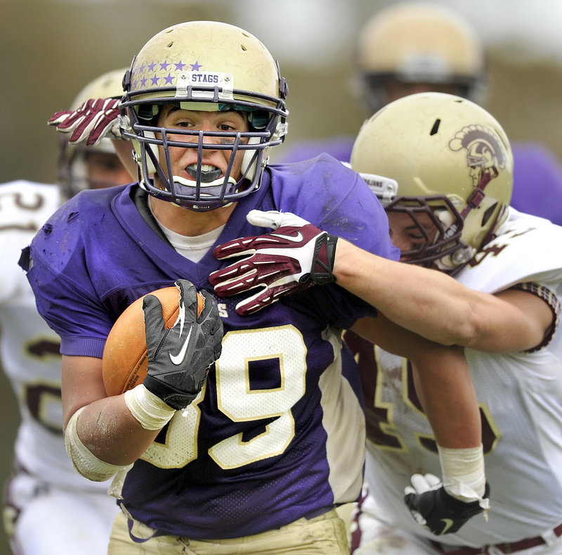 Cody O'Brien of Cheverus chugs down the field Saturday while attempting to beak away from Jimmy Remmes of Thornton Academy during Cheverus' 56-7 victory at home.