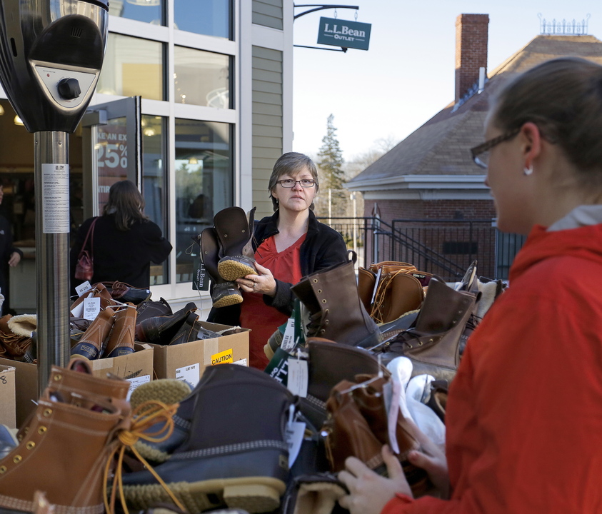 Becky Clarke of Oakfield shows a pair of boots to her daughter Emily Clarke, foreground, as the two shop for Black Friday deals at the L.L. Bean outlet in Freeport on Friday.