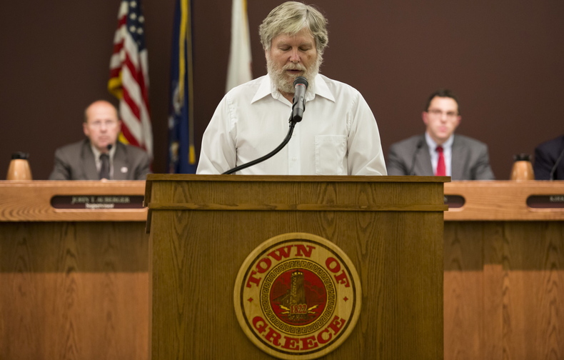 Tom Lynch delivers a Baha’i prayer before the start of a town board meeting in Greece, N.Y., on Aug. 20. The Supreme Court soon will take up the case of the Town of Greece v. Galloway, concerning use of public prayers before town meetings.