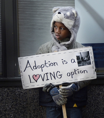 Leslie Sneddon of Richmond, above, protests outside Planned Parenthood on Congress Street in Portland on Friday. Abraham Hebert, 8, of Waterboro, left, holds a sign among the protesters outside the entrance to Planned Parenthood’s clinic. Photos by Shawn Patrick Ouellette/Staff Photographer