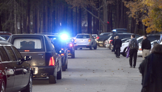 A police escort leads a motorcade after a memorial service for Deering High coach Brendan Conway held Tuesday held at the school.