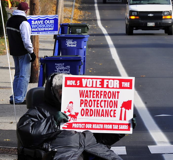 Proponents and opponents of the Waterfront Protection Ordinance hold competing signs Tuesday, when South Portland residents voted on the issue.
