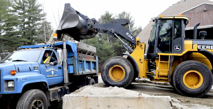 Skowhegan Highway Department employees Jason Kirk, in truck, and Duane Whittemore team up Tuesday at the town’s sand shed to get a mixture of sand and salt loaded for treating roads in anticipation of Wednesday’s storm.