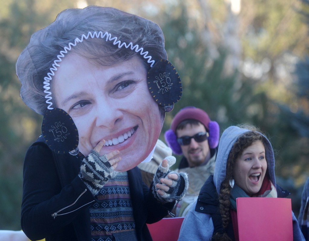 James Maloney-Hakins, 21, holds a cut-out of University of Maine at Farmington President Kate Foster on the Alpha Lambda Delta float before the annual Chester Greenwood Day parade in downtown Farmington on Saturday.