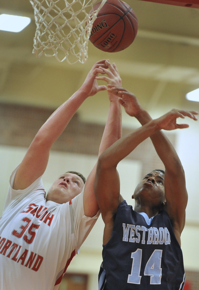 Jaren Muller, left, who scored 33 points and pulled down 14 rebounds for South Portland, battles with Westbrook’s Demetrius Hoskins during Friday’s game in South Portland