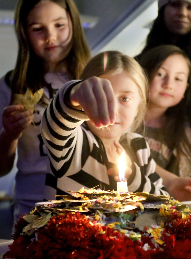 Sugar represents joy, so Bella Martin, 6, of Limerick uses it to sweeten despacho and prayer alike as cousins Brooke Rousey, 11, left, and Lainey Rousey, 8, watch.