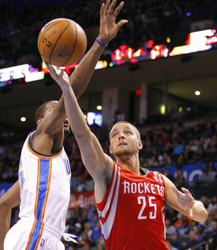 Houston’s Chandler Parsons drives to the basket around Oklahoma City’s Kevin Durant during the first quarter of Sunday’s game in Oklahoma City, won by the Thunder.