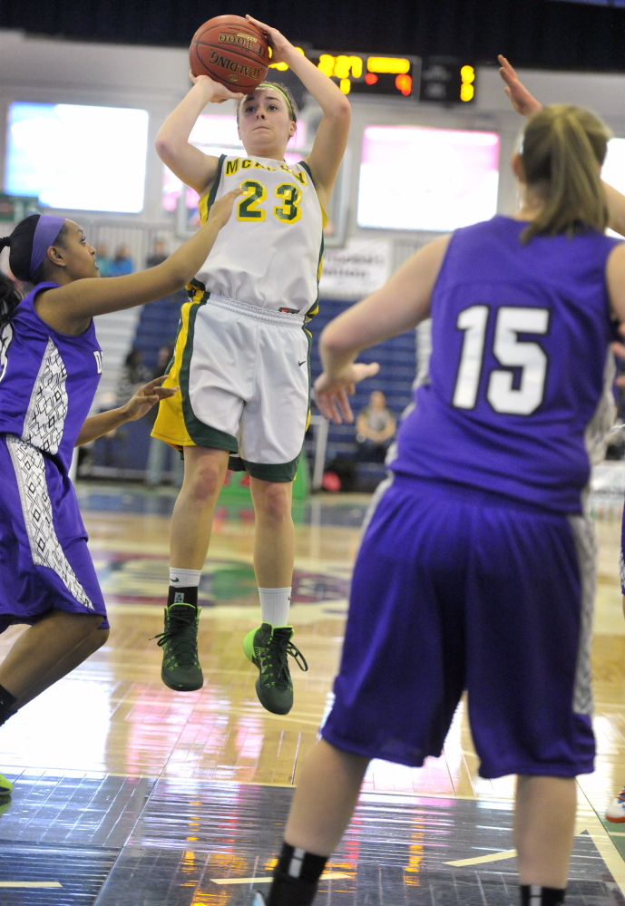 Allie Clement of McAuley pulls up for a jumper over the Deering’s Mary Tadsse, left, while LeeAnn Downs looks on Monday during a Western Class A girls’ basketball quarterfinal at the Portland Expo. McAuley won, 52-30.