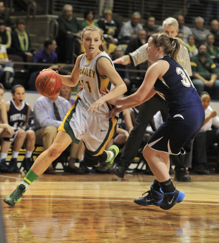 Olivia Smith of McAuley drives against Portland’s Brianna Holdren during their Western Class A girls’ basketball semifinal Friday night at the Cumberland County Civic Center. Smith scored 15 points to help McAuley advanced to the regional final with a 70-38 victory.