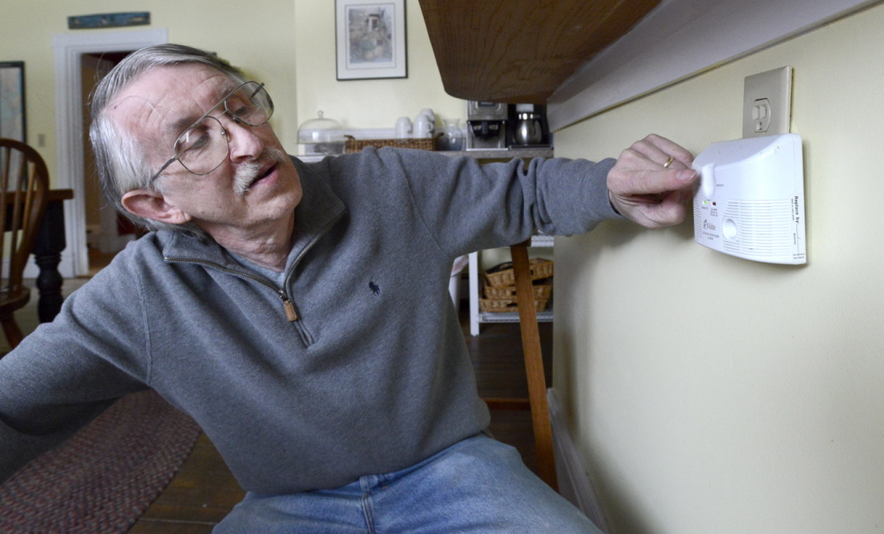 Owner Tim Rudolph checks a plug-in carbon monoxide detector at the Kendall Tavern Inn, a bed-and-breakfast in Freeport. Rudolph said he and his wife bought the unit several years ago and they keep it in their kitchen. “You don’t even see it,” he said.