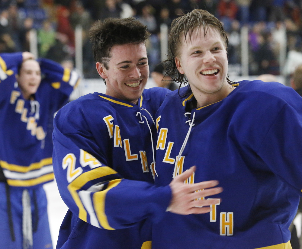 Jake Grade, left, and Isac Nordstrom celebrate after Grade scored the overtime goal that put Falmouth atop Class A hockey in the state for the second straight season.