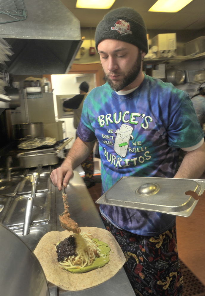 Christopher Hall adds ingredients to a burrito for a lunchtime customer.