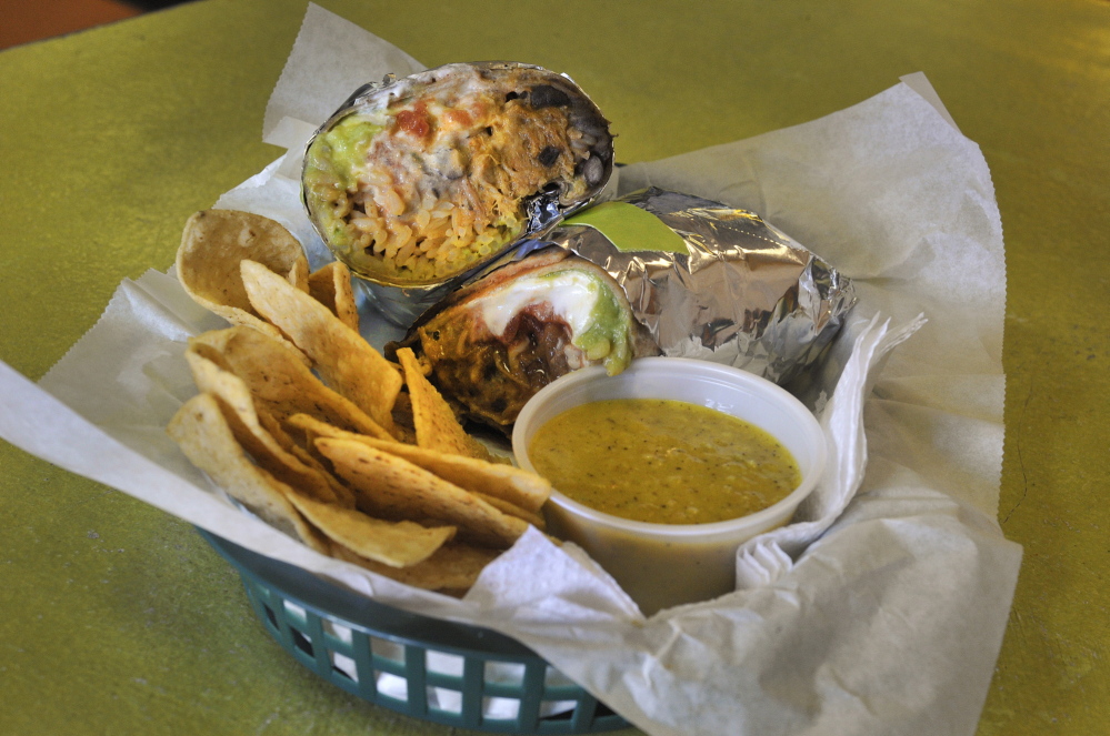 A basic burrito with a side of chips and salsa.