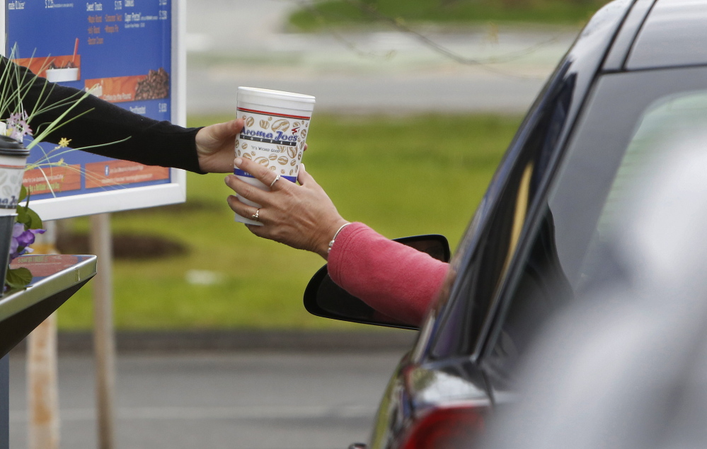 An Aroma Joe’s customer receives coffee in Saco. “We have a mission of providing a wicked good cup of coffee to one customer at a time,” an owner says.