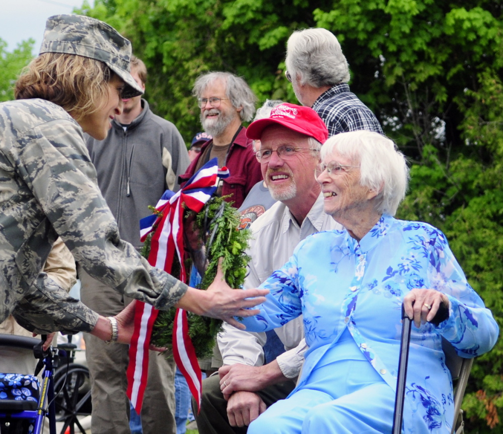 Air Force Reserves Lt. Col. Lorinda Fontaine Farris, left, takes a wreath from Priscilla Berry Stevenson, right, to place on a memorial to Wayne men killed in two world wars.