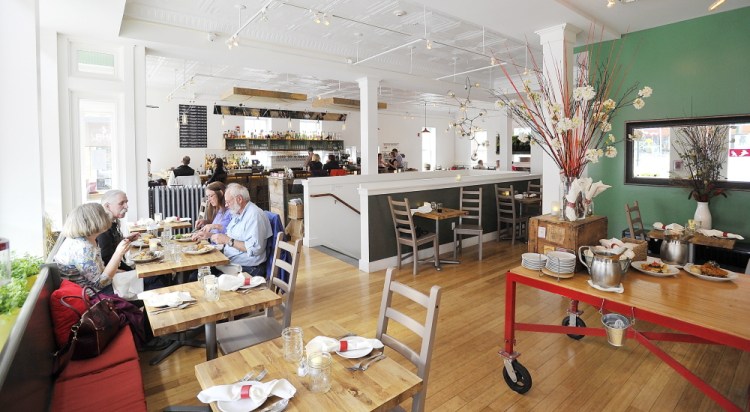 Friends enjoy a window table at 3 Crow in Rockland. All the tables at the restaurant are made from reclaimed wood.