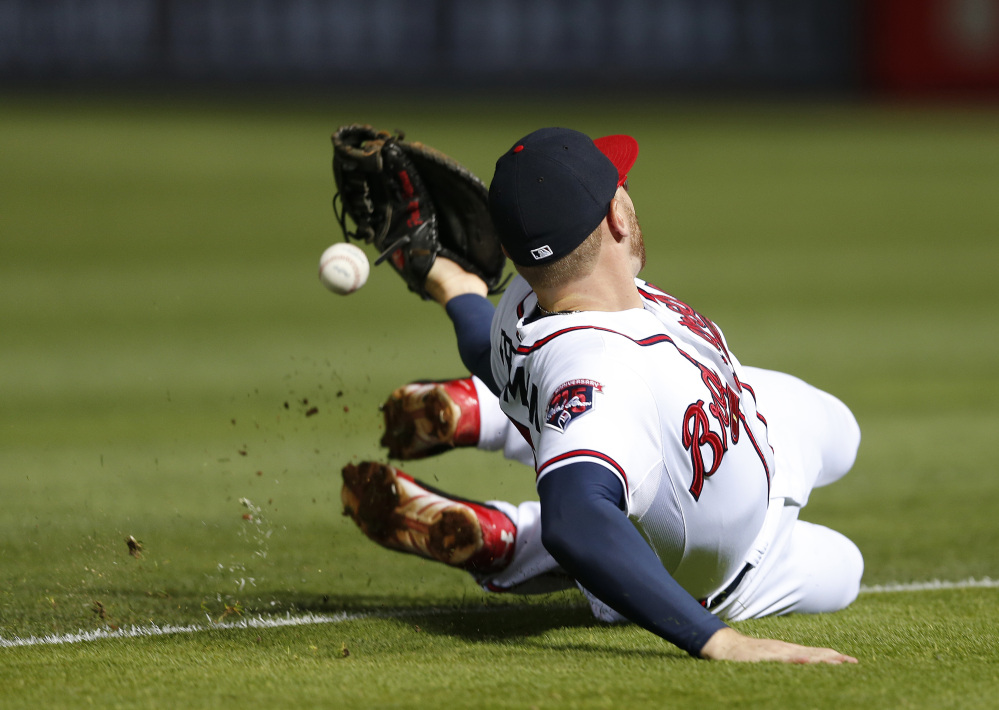 Atlanta Braves first baseman Freddie Freeman canât reach an RBI single by Boston Red Soxâs Jonny Gomes in the seventh inning of a baseball game Tuesday, May 27, 2014, in Atlanta. The Associated Press/John Bazemore