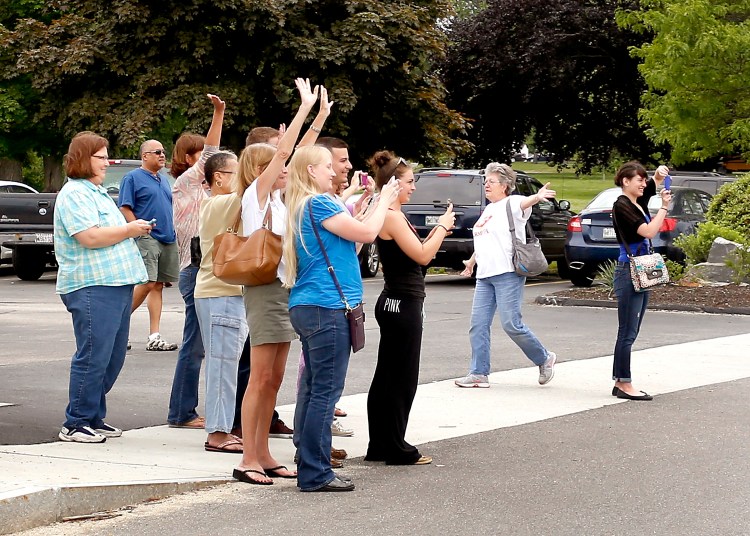 Fans cheer across the street from Uncle Andy's in South Portland on Tuesday. Uncle Andy's is being featured on Restaurant Impossible. 