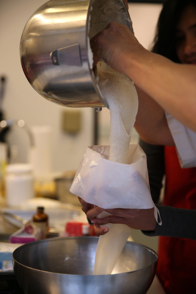 Pastry class instructor Madelaine Bullwinkel pours an almond mixture into a piping bag while making macarons at the Alliance Francaise de Chicago.