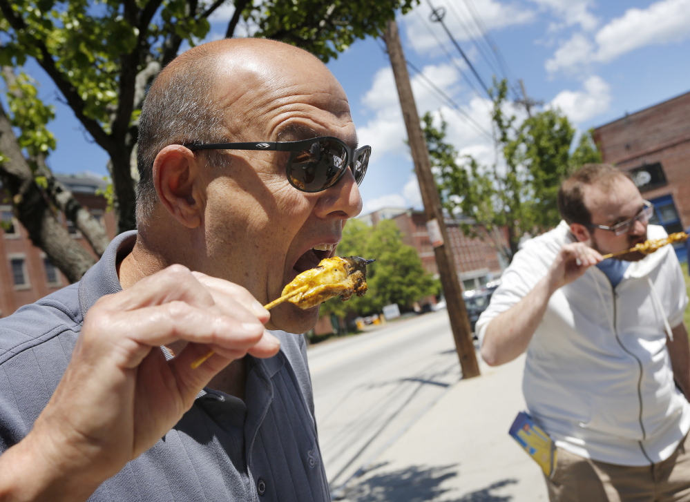 David Cavalero of Scarborough samples grilled dogfish skewers during the Old Port Festival last weekend. Derek Davis/Staff Photographer