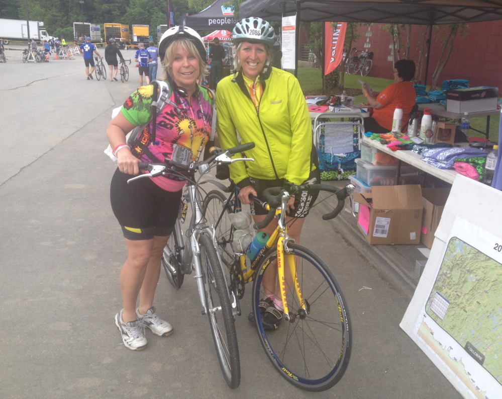 Sisters Diana LeRoux, left, and Joanne Mason relax at Colby College in Waterville after crossing the finish line for the second leg of the Trek Across Maine on Saturday.