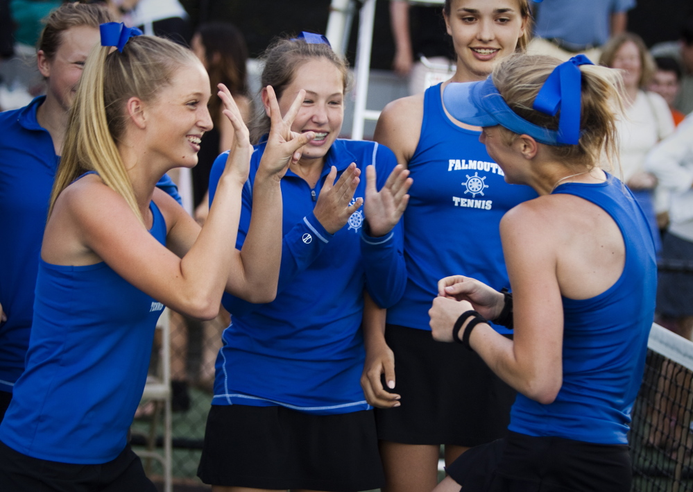 Olivia Leavitt, right, is greeted by teammates after helping Falmouth win the Class A tennis state title Monday in Lewiston.