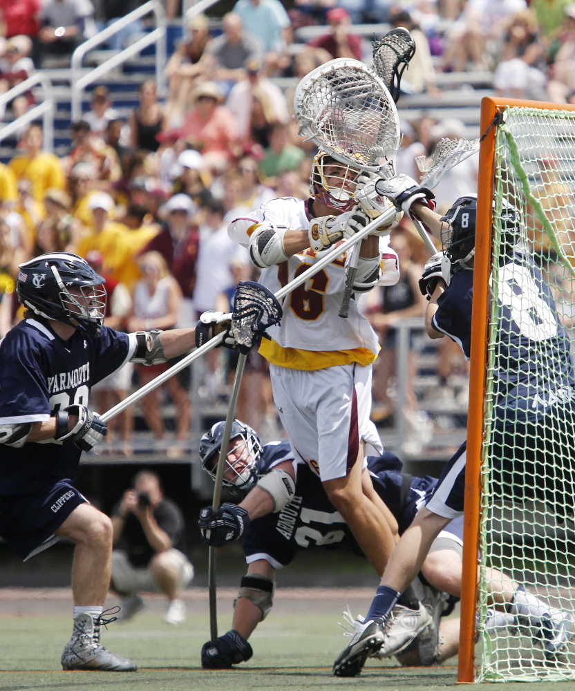 Yarmouth’s Garrett Flanagan, left, Thomas Lord, and Connor Hoehle do everything they can to deny a shot by Noah Haversat of Cape Elizabeth. The unbeaten Capers defeated Yarmouth in the state final for the second year in a row.