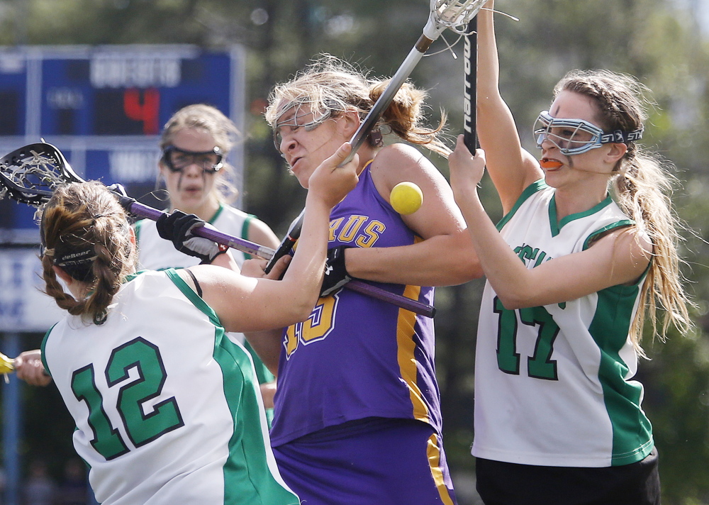 Alex Logan of Cheverus finds little room to manuever between Mia Kuni, left, and Sierra Arral during Massabesic’s sudden-death victory in the Class A state final at Fitzpatrick Stadium.