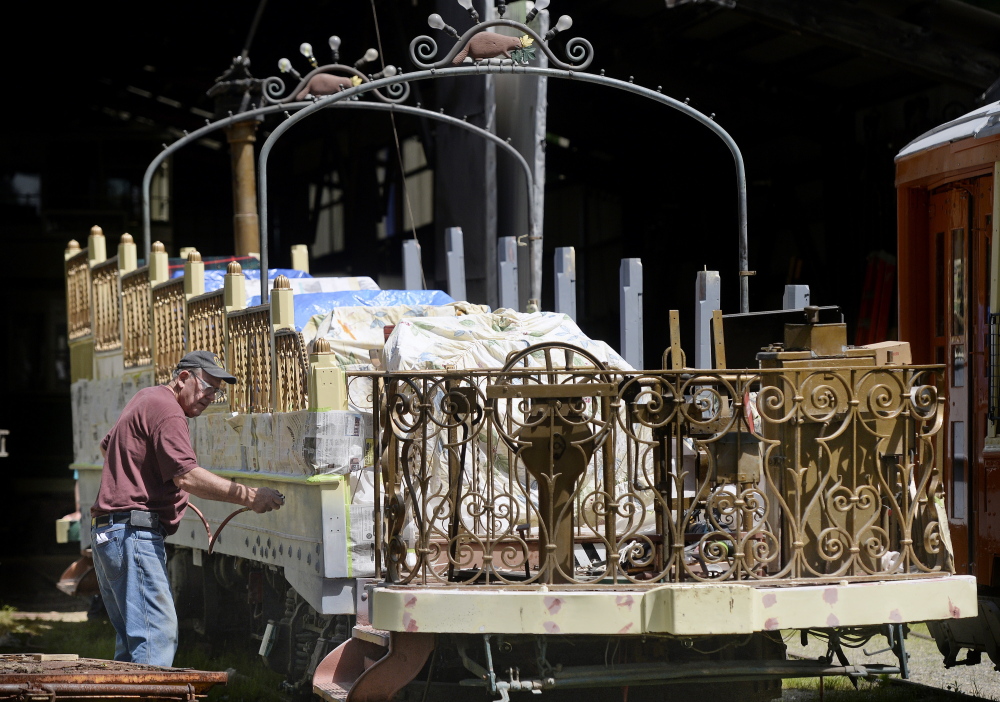 Jim Mackell, a volunteer from Arundel, puts a coat of primer on the 1906 Montreal “Golden Chariot” observation car at the Seashore Trolley Museum in Kennebunkport. The observation car will return to use during a July 5 celebration.