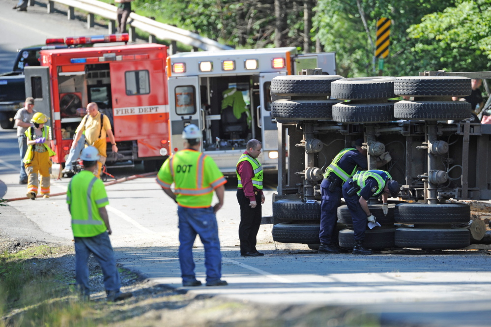 Staff photo by Michael G. Seamans
Investigators inspect a logging truck that flipped and hit an SUV on U.S. Route 201 in Moscow on Thursday. Two adults and a baby from the SUV were transported to the hospital by ambulance with unknown injuries and a third adult from the vehicle was transported by LifeFlight.  The truck driver was also taken to the hospital.