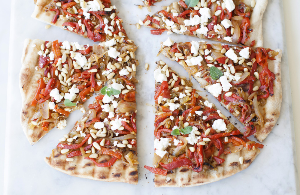 Grilled white pizza with caramelized onion and garlic takes a Middle Eastern turn when topped with roasted red peppers, pine nuts and feta.