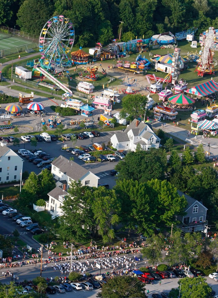 A crowd lines the street for the annual Yarmouth Clam Festival parade as the midway sits in the background during Friday’s opening-night celebration. Jill Brady/Staff Photographer