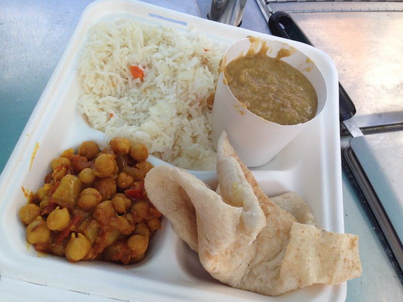 A thali plate with chana masala and dal.