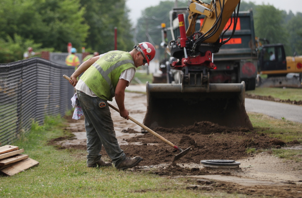 Workers cover gas pipes installed in Cumberland last week by Summit Natural Gas of Maine or its contractors.