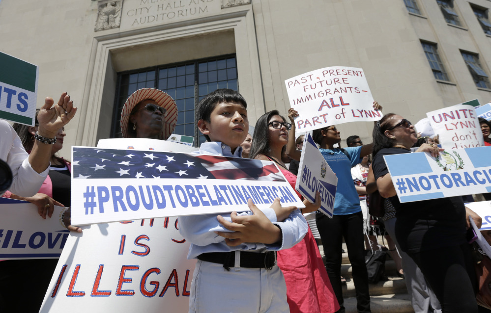 Christian Gonzalez, 9, of Lynn, Mass., displays a placard during a rally Tuesday on the steps of City Hall in Lynn, held to protest what organizers describe as the scapegoating of immigrants for problems in the city. Education officials complain their schools are being overwhelmed by young Guatemalans who speak neither English nor Spanish. Gonzalez, a U.S. citizen, was born in Boston.